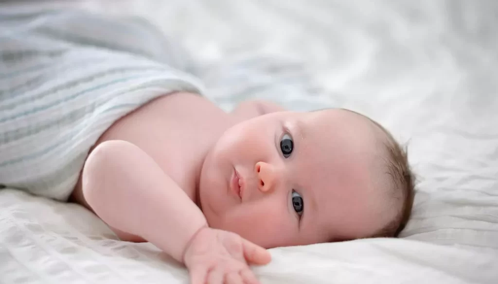 Un enfant abandonné parmi des déchets avec un chapelet